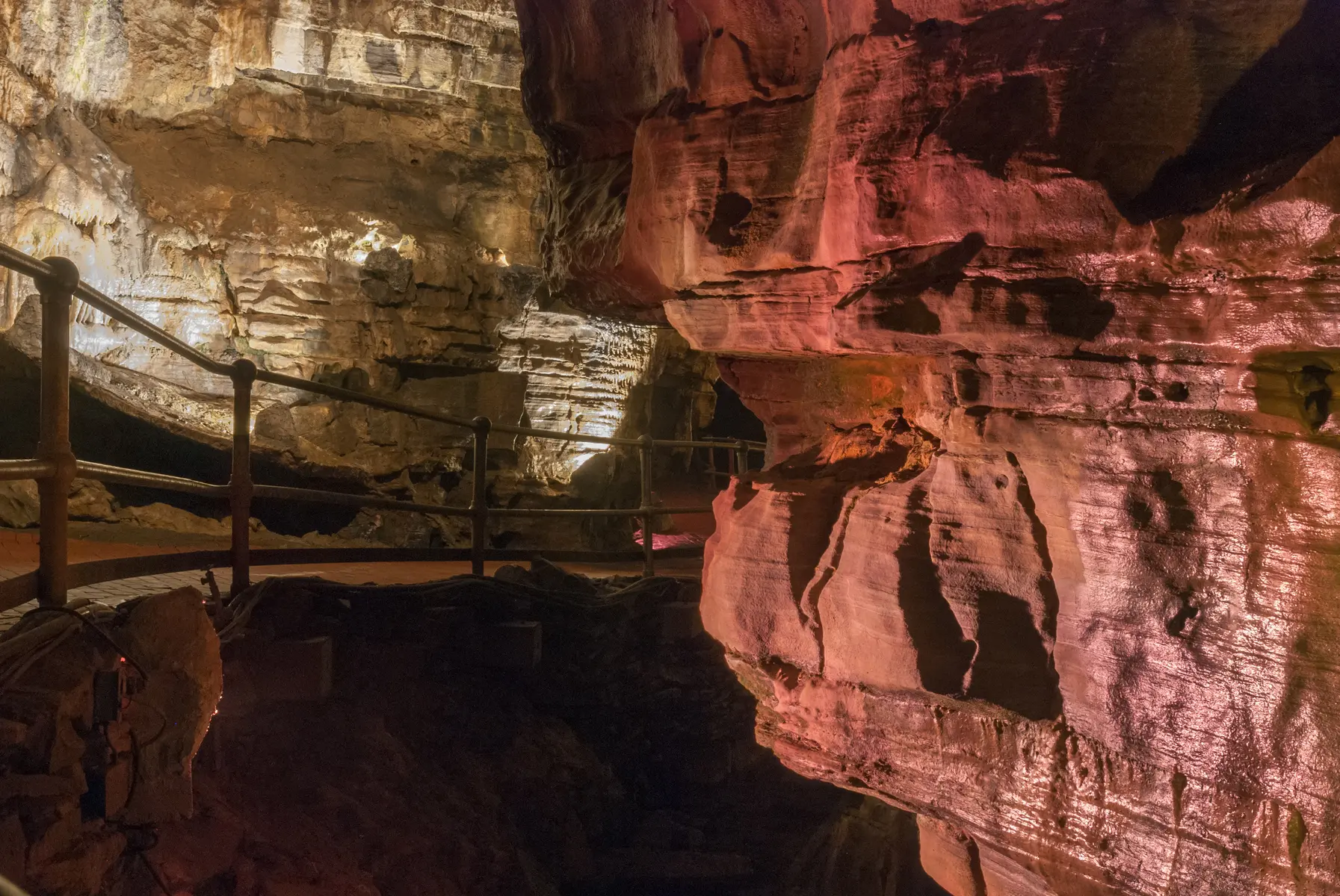 Illuminated limestone passage and visitor walkway inside Howe Caverns in Howes Cave, New York