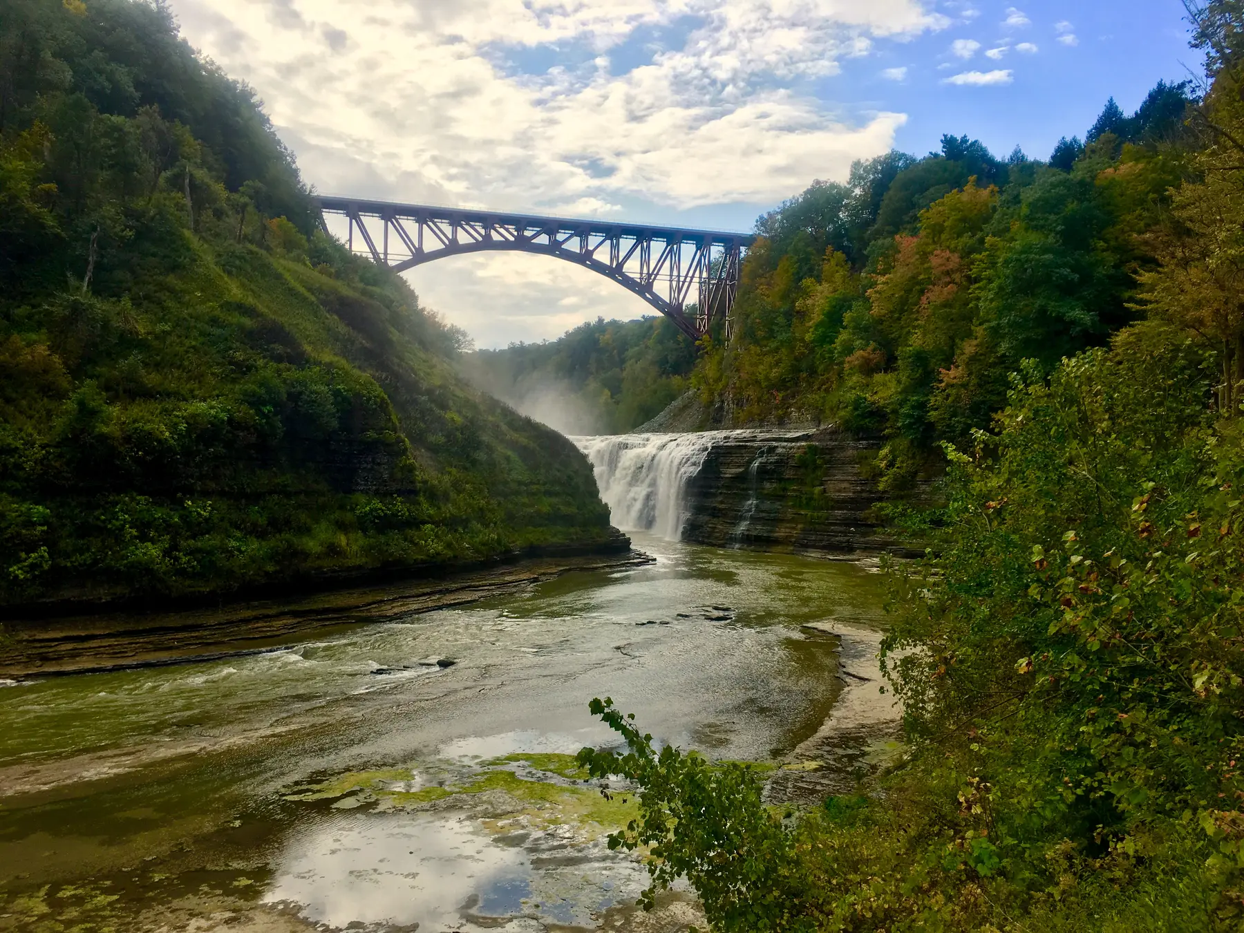 Upper Falls and the Genesee Arch Bridge framed by autumn forest at Letchworth State Park