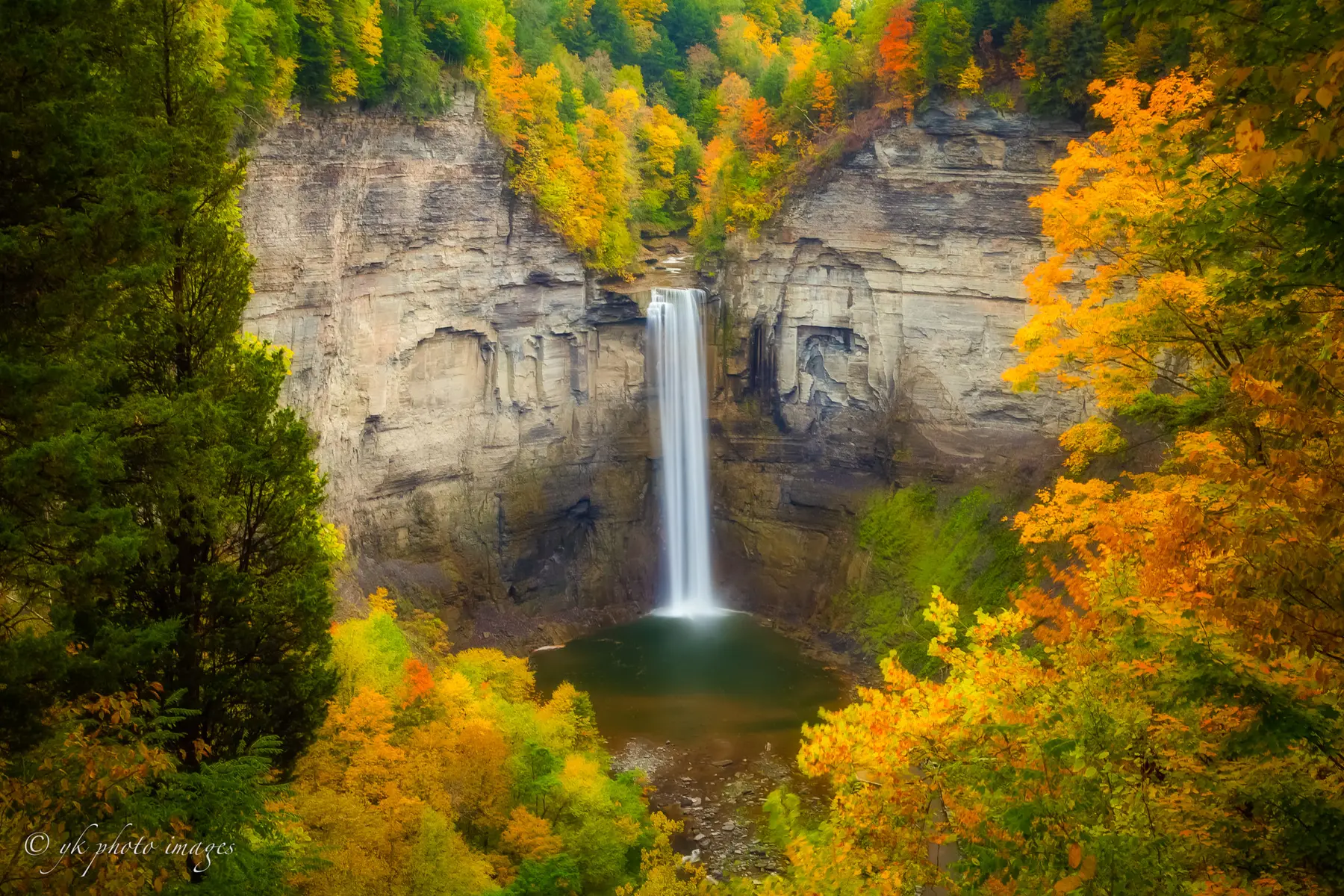Taughannock Falls dropping through a rock amphitheater surrounded by autumn color